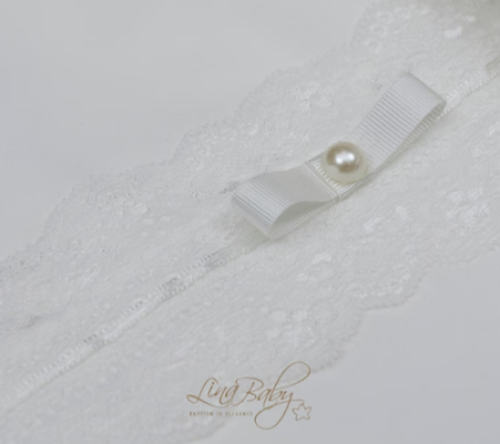 Close-up of a textured white fabric with a pearl accent and 'Living Baby' branding.